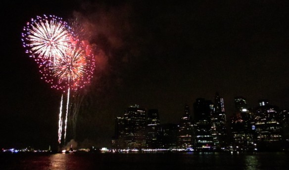 Macy's fireworks and Manhattan skyline in New York seen from Brooklyn Bridge Park